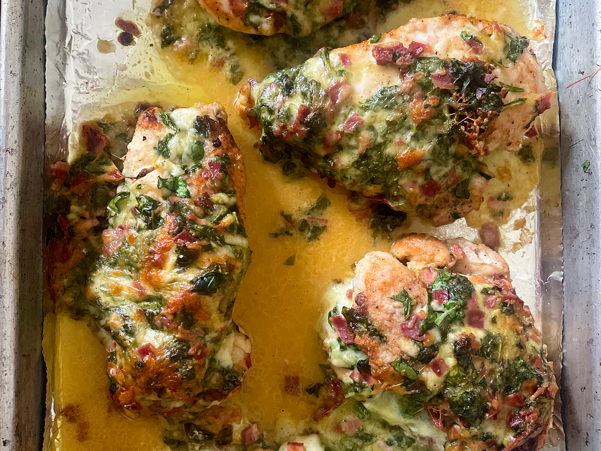 close up view of Chicken Breast Stuffed with Spinach Blue Cheese and Bacon on a baking sheet