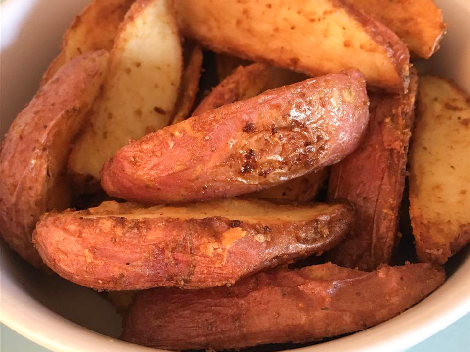 close up view of Seasoned Baked Potato Wedges in a bowl