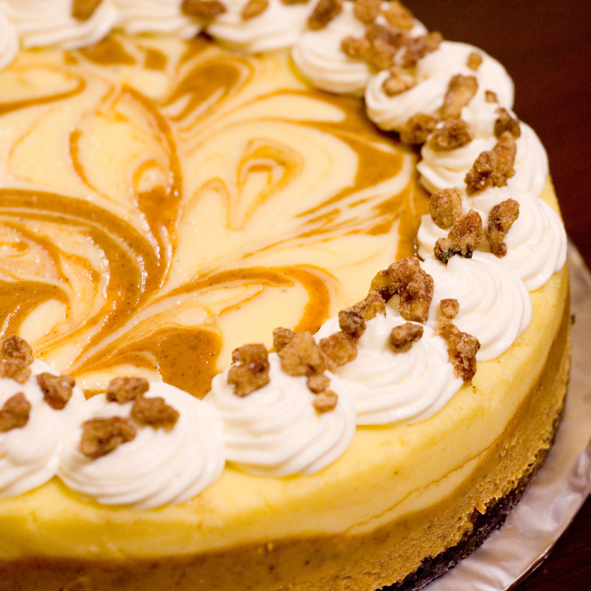 close up view of Marbled Pumpkin Cheesecake garnished with icing and nuts