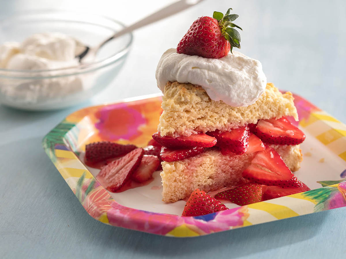 close up view of a Strawberry Shortcake with fresh strawberries and cream on a plate