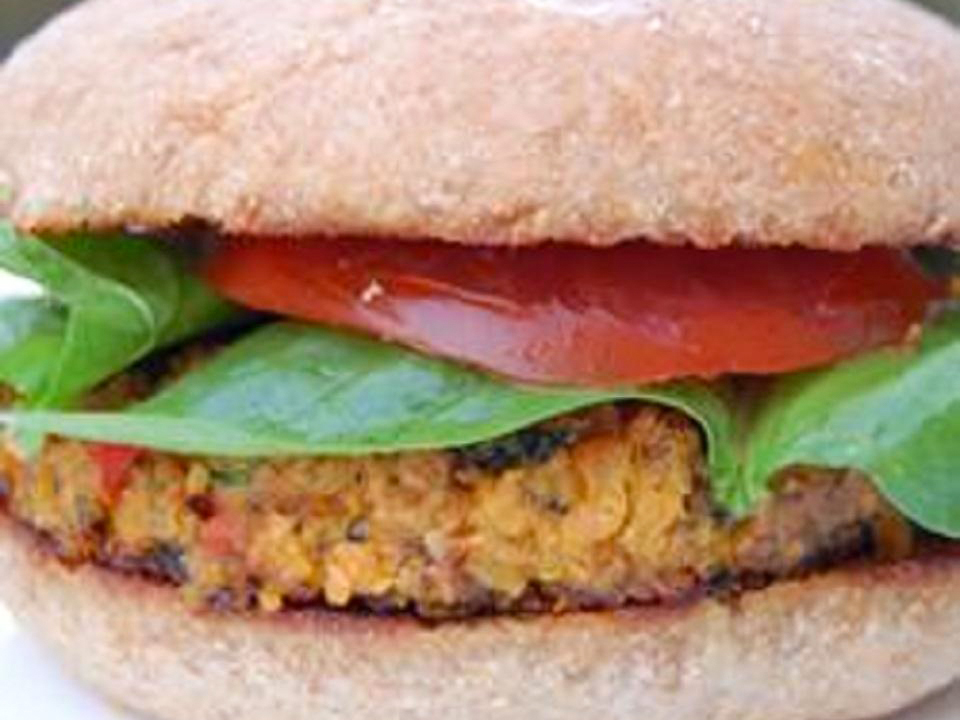 close up view of a Lentil Burger with lettuce and tomato on a bun