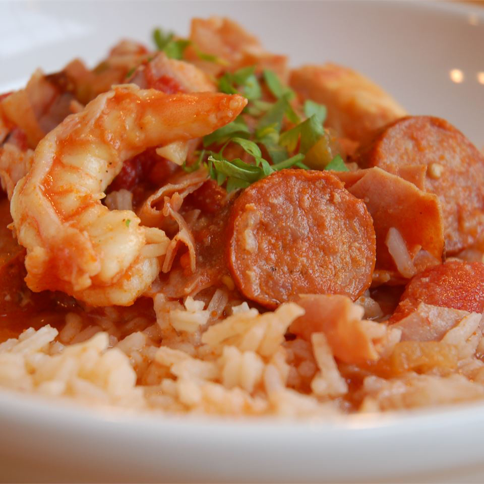 close up view of Oven Baked Jambalaya with shrimp and sausage, garnished with fresh herbs over rice in a bowl