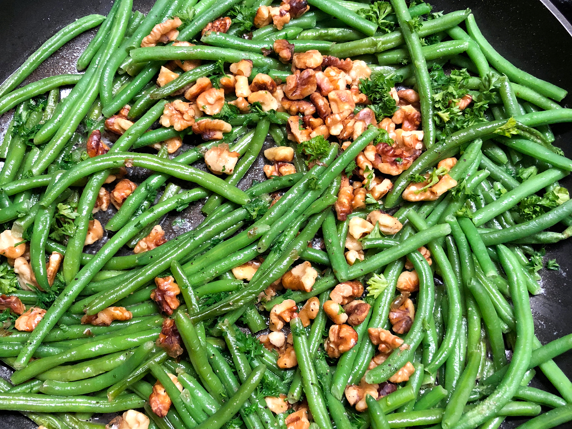 close up view of Green Beans With Walnuts in a pan