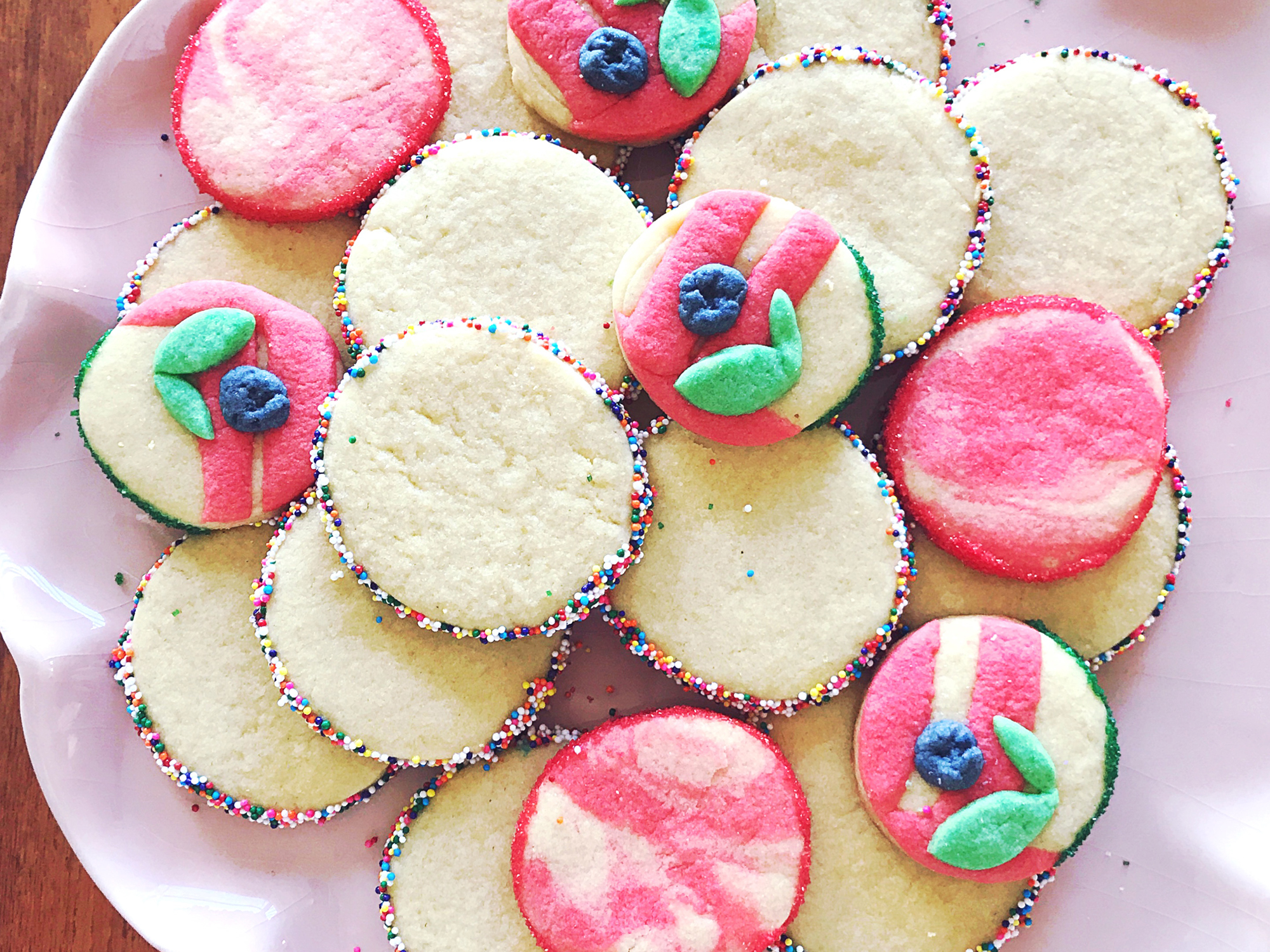 close up view of Sugar Cookies garnished with sprinkles on a pink platter