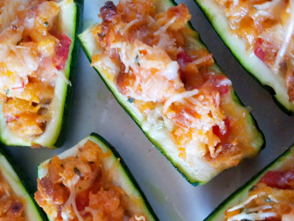 close up view of Stuffed Zucchini with cheese on a baking sheet