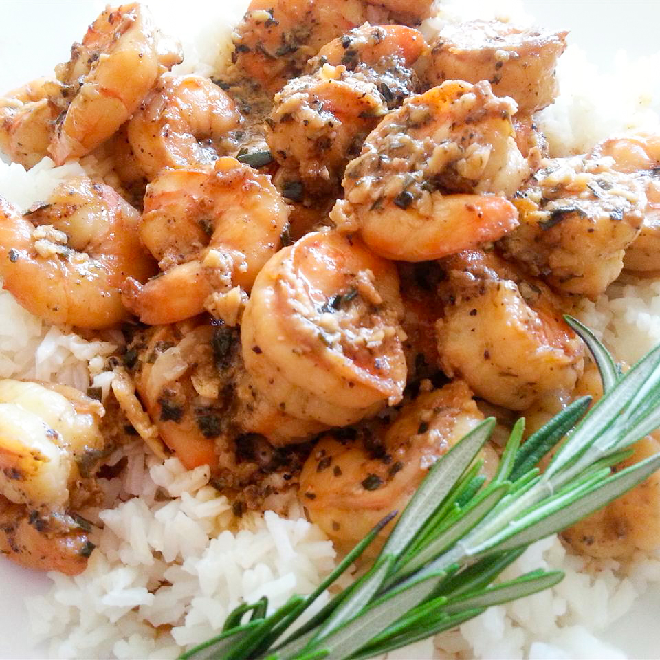 close up view of Barbequed Shrimp over white rice, garnished with fresh rosemary