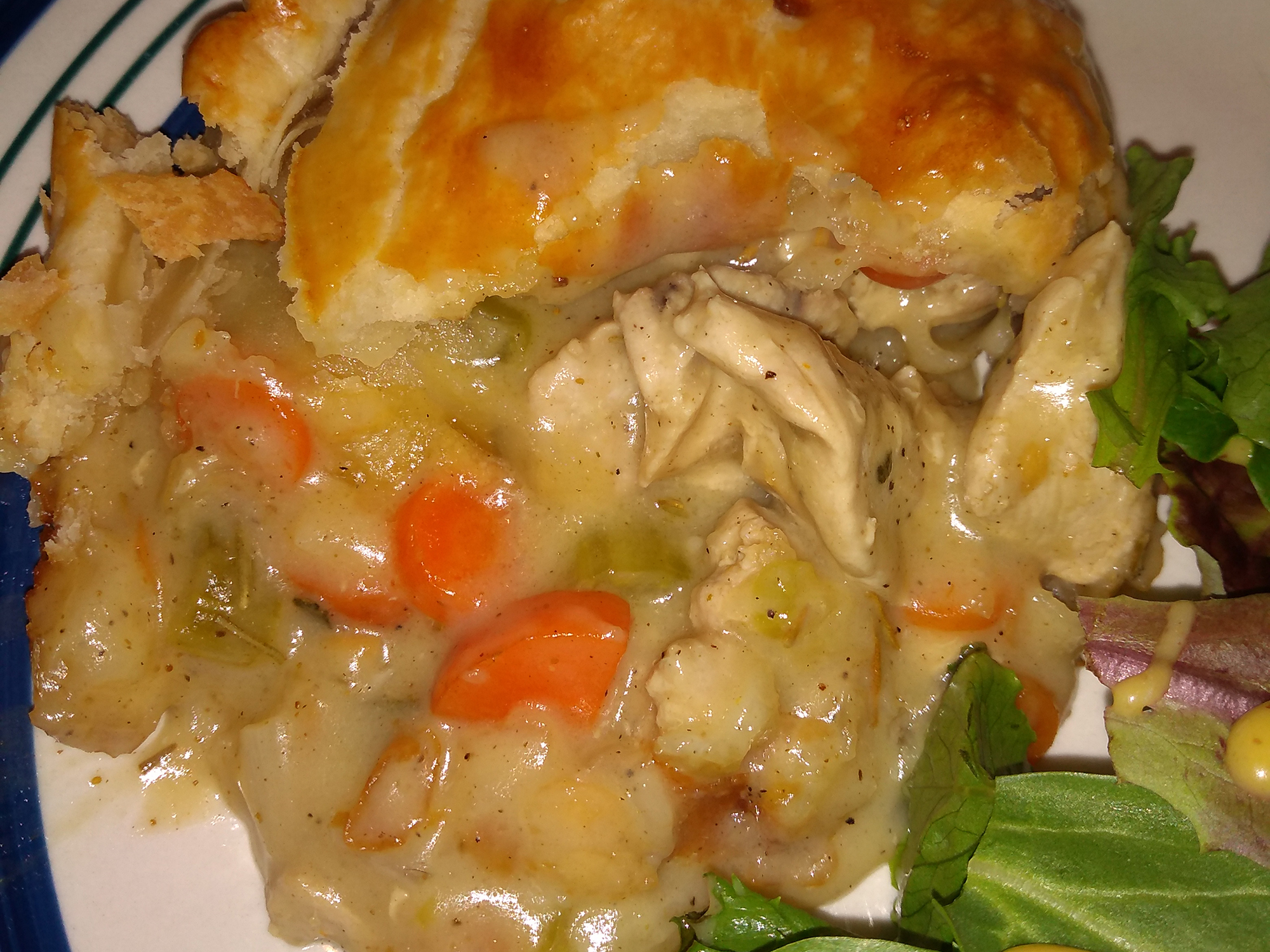 close up view of a piece of Pheasant Pot Pie served with salad on a plate
