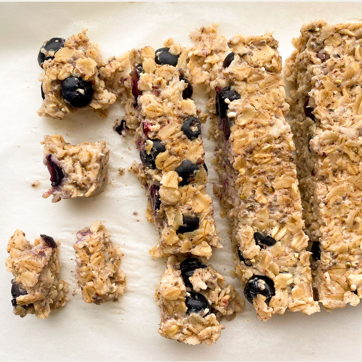 close up view of Weaning Oatmeal Bites with blueberries on a parchment paper line baking sheet
