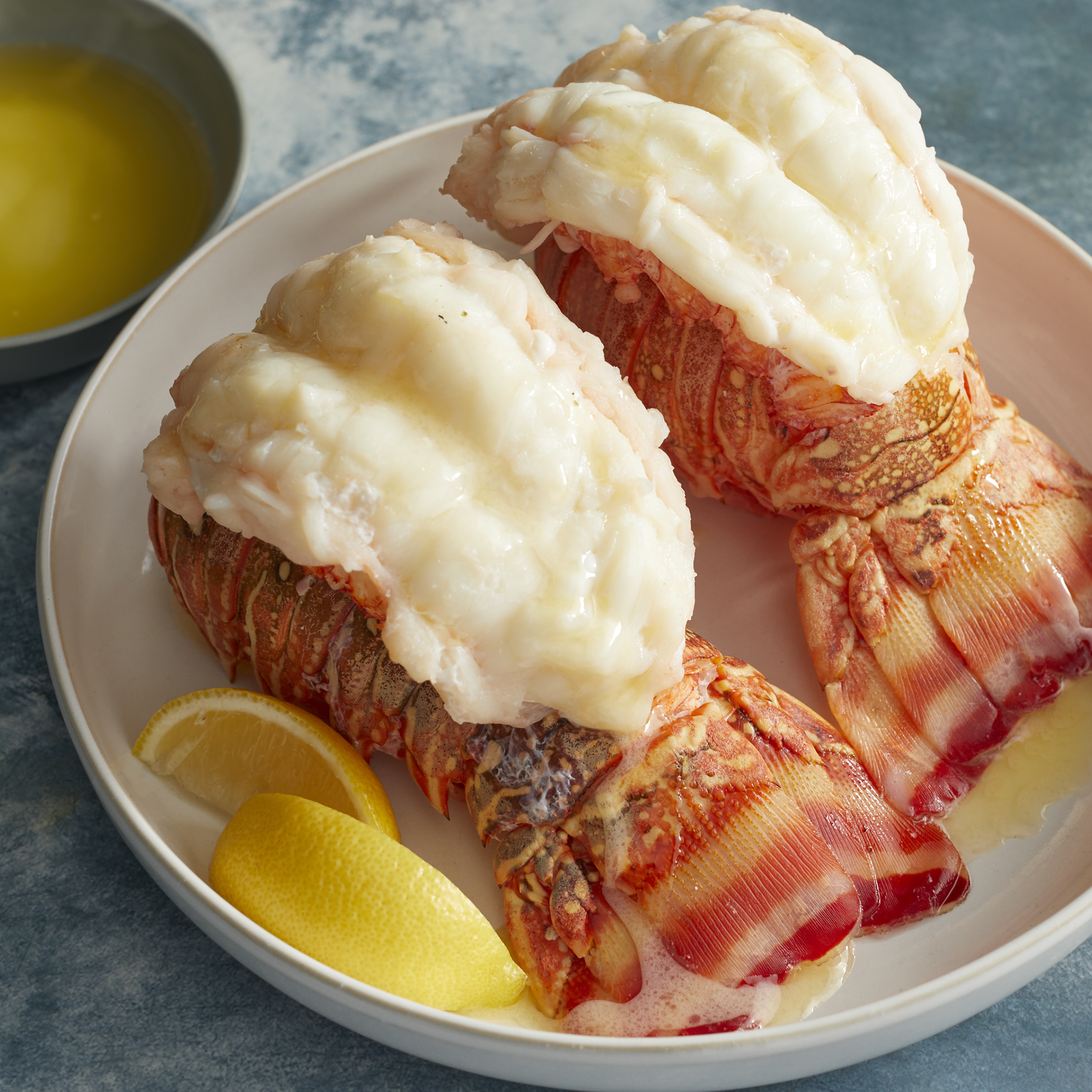 looking down at a plate of two steamed lobster tails