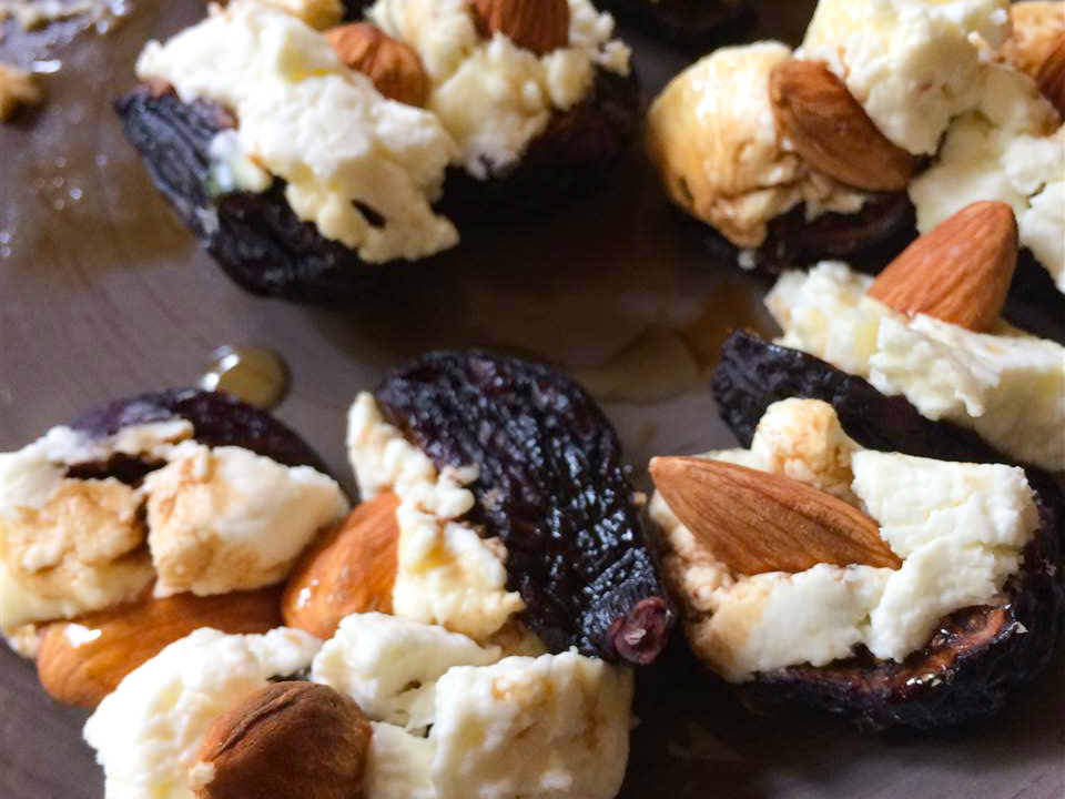 close up view of Fig Appetizers with Goat Cheese and Almonds on a baking sheet