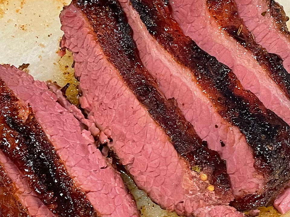 close up view of a sliced Dutch Oven Crunchy Corned Beef on a cutting board