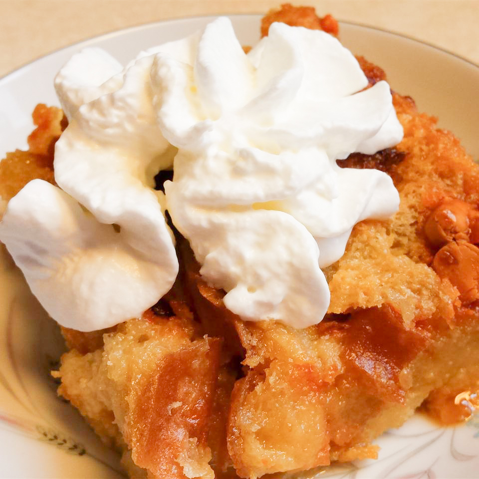 close up view of Butterscotch Bread Pudding garnished whipped cream in a bowl