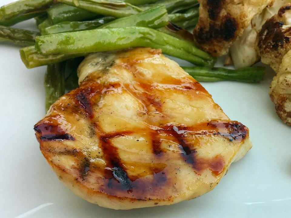 close up view of Honey Grilled Chicken served with green beans and cauliflower on a plate