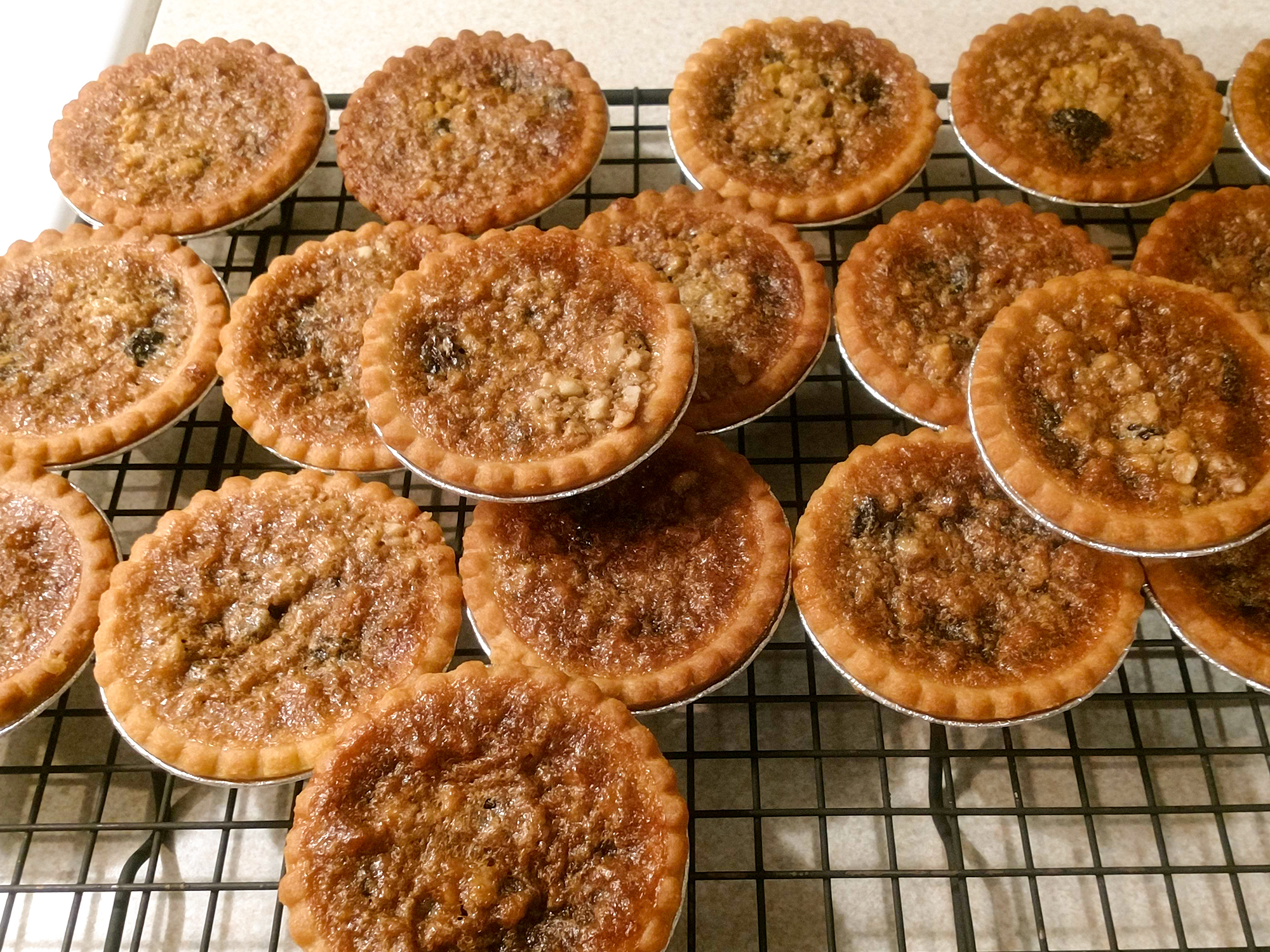 close up view of a pile of Butter Tarts on a cooling rack