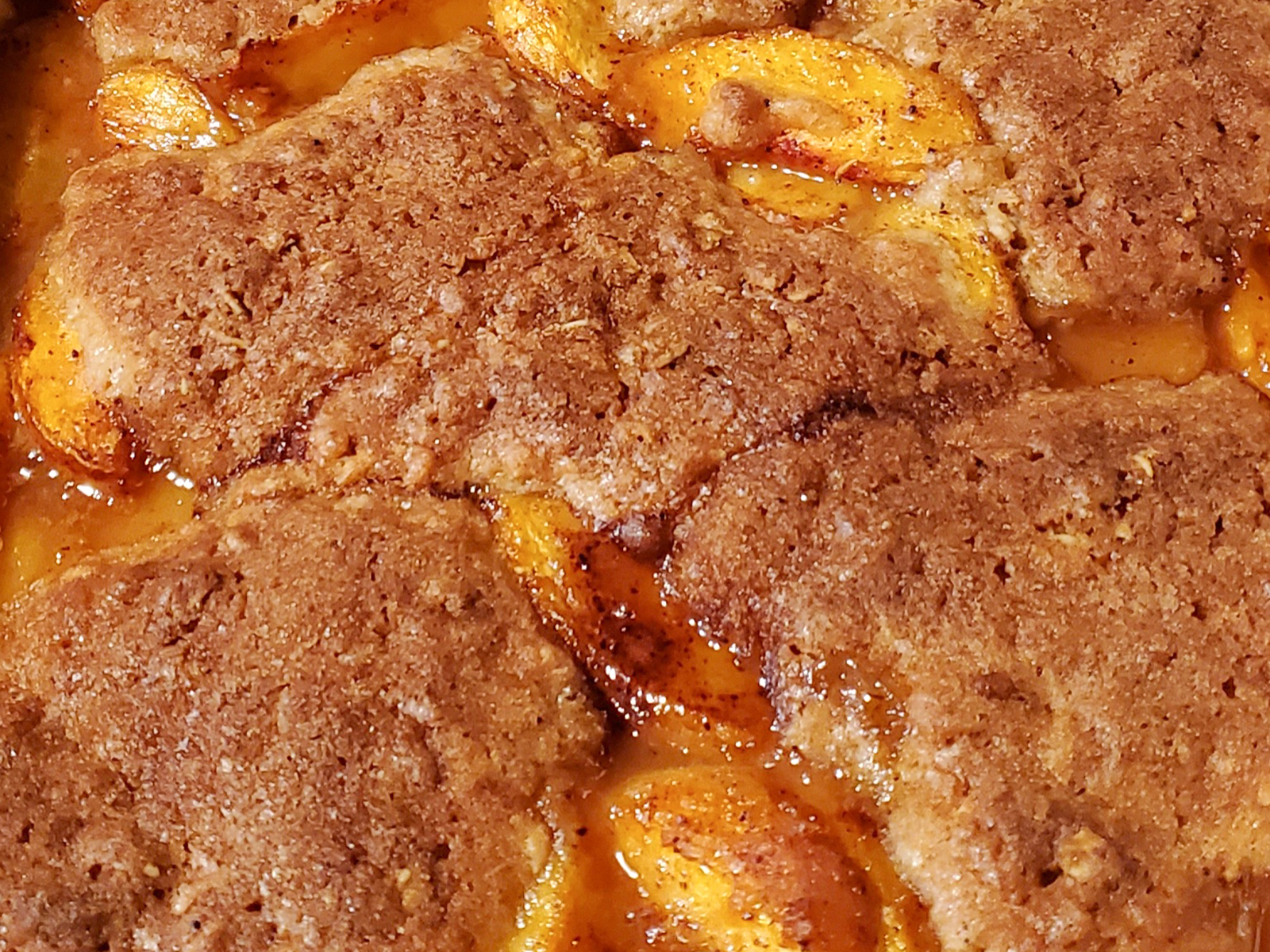 close up view of Southern Peach Cobbler in a baking dish