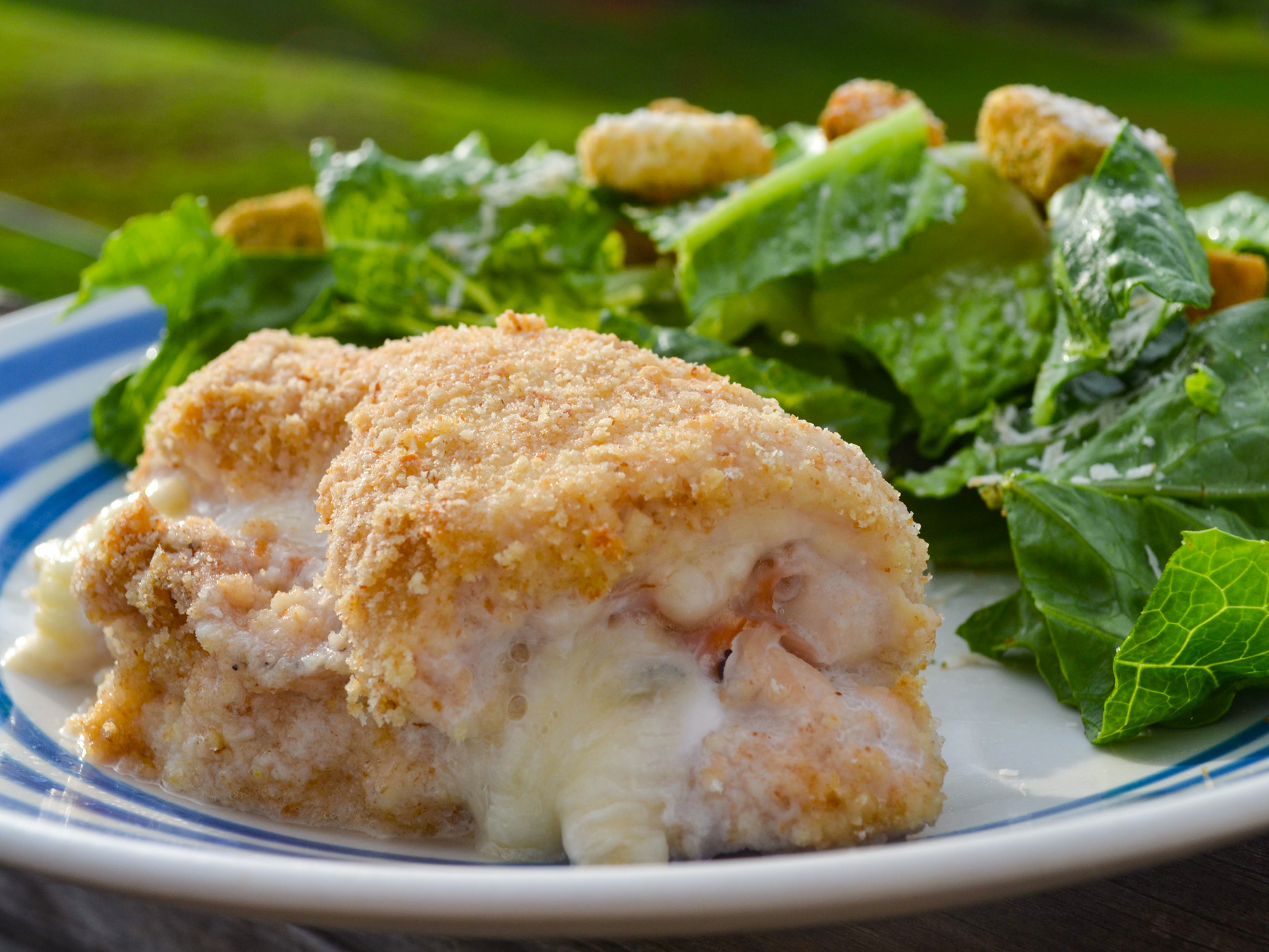 close up view of Baked Chicken Cordon Bleu served with salad on a plate