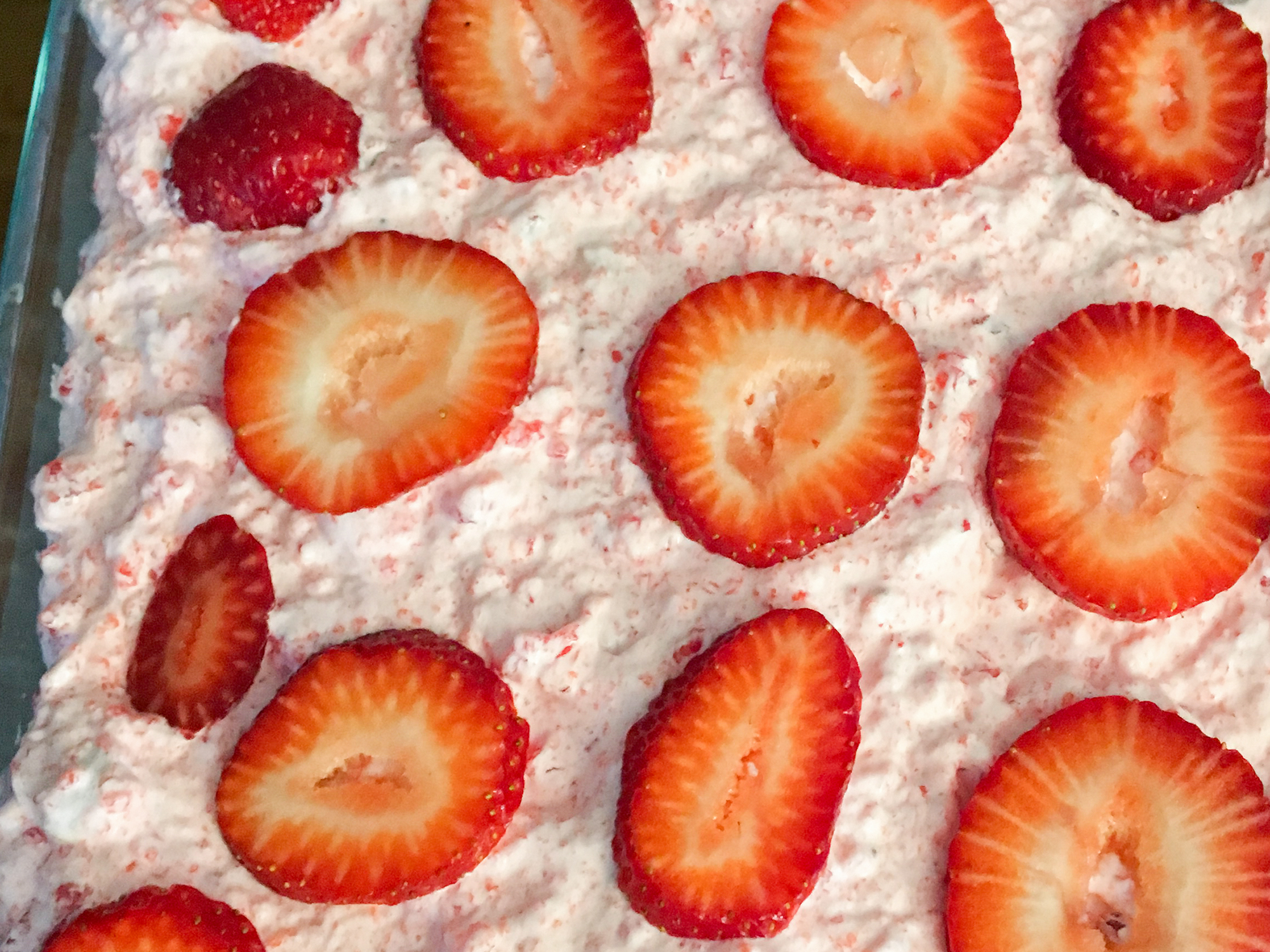 close up view of Strawberry Whip garnished with strawberry slices in a glass baking dish