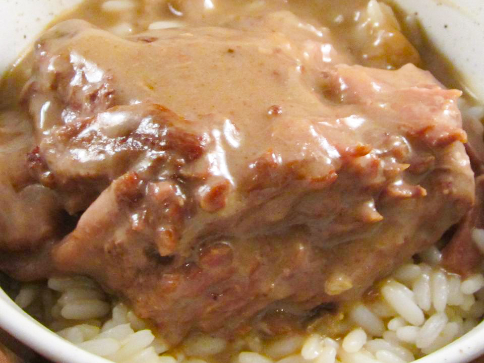 close up view of Roast Beef and Gravy over rice in a white bowl