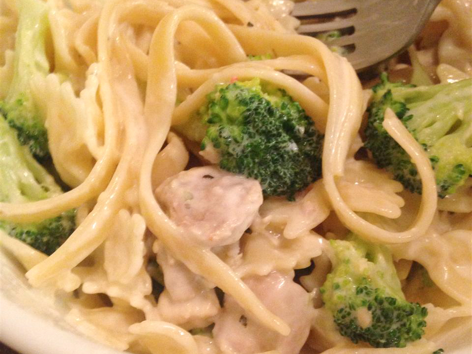close up view of Chicken and Broccoli Alfredo in a bowl with a fork