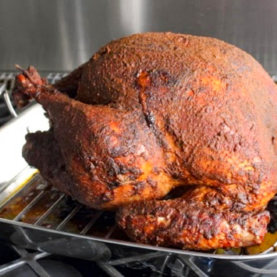 close up view of a Roasted Peruvian Turkey in a roasting pan on the stove