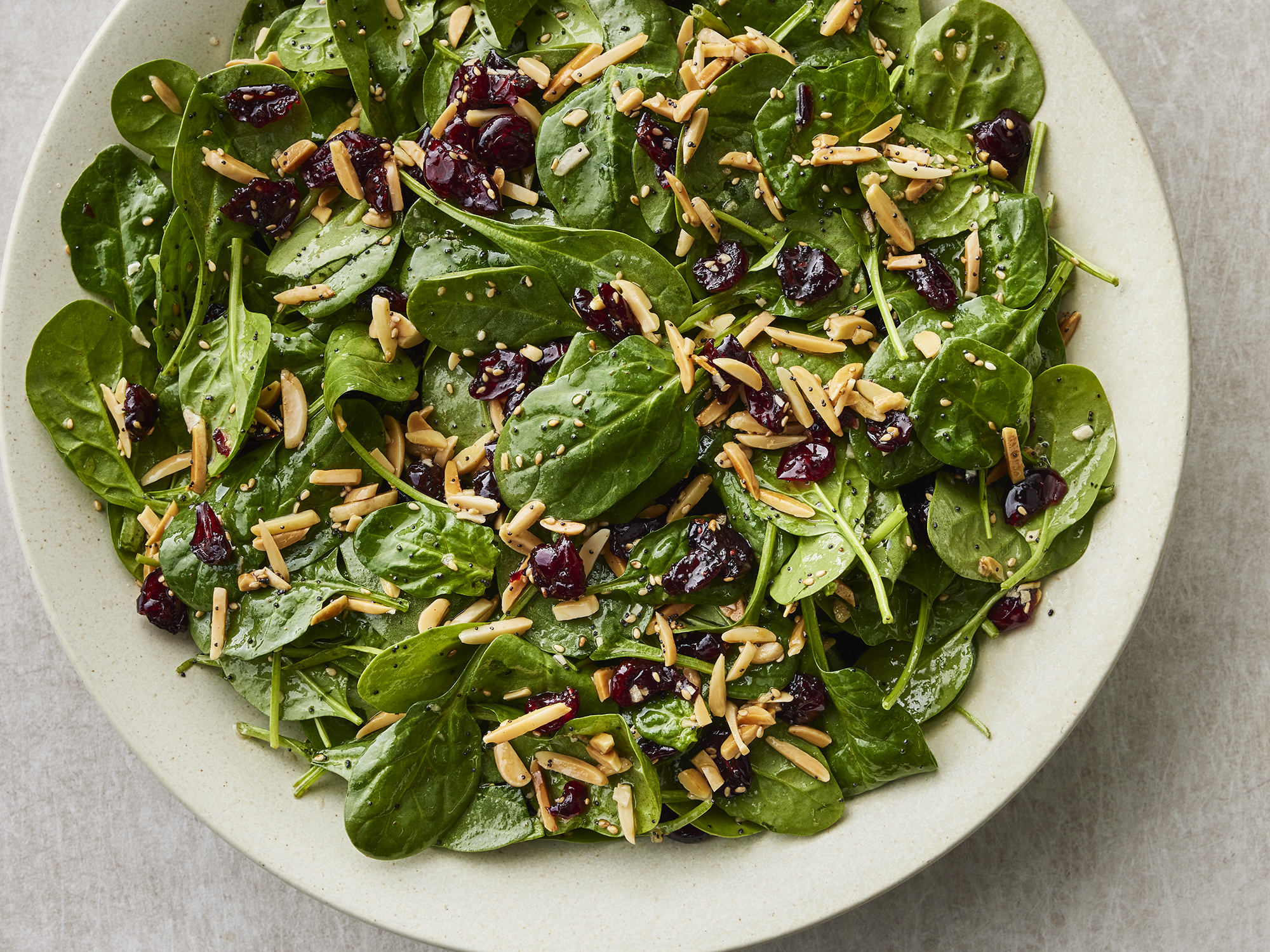 very close up on a plate of cranberry spinach salad