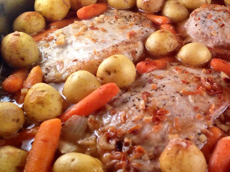 close up view of Pork Chop Casserole with carrots, potatoes and onions in a baking dish