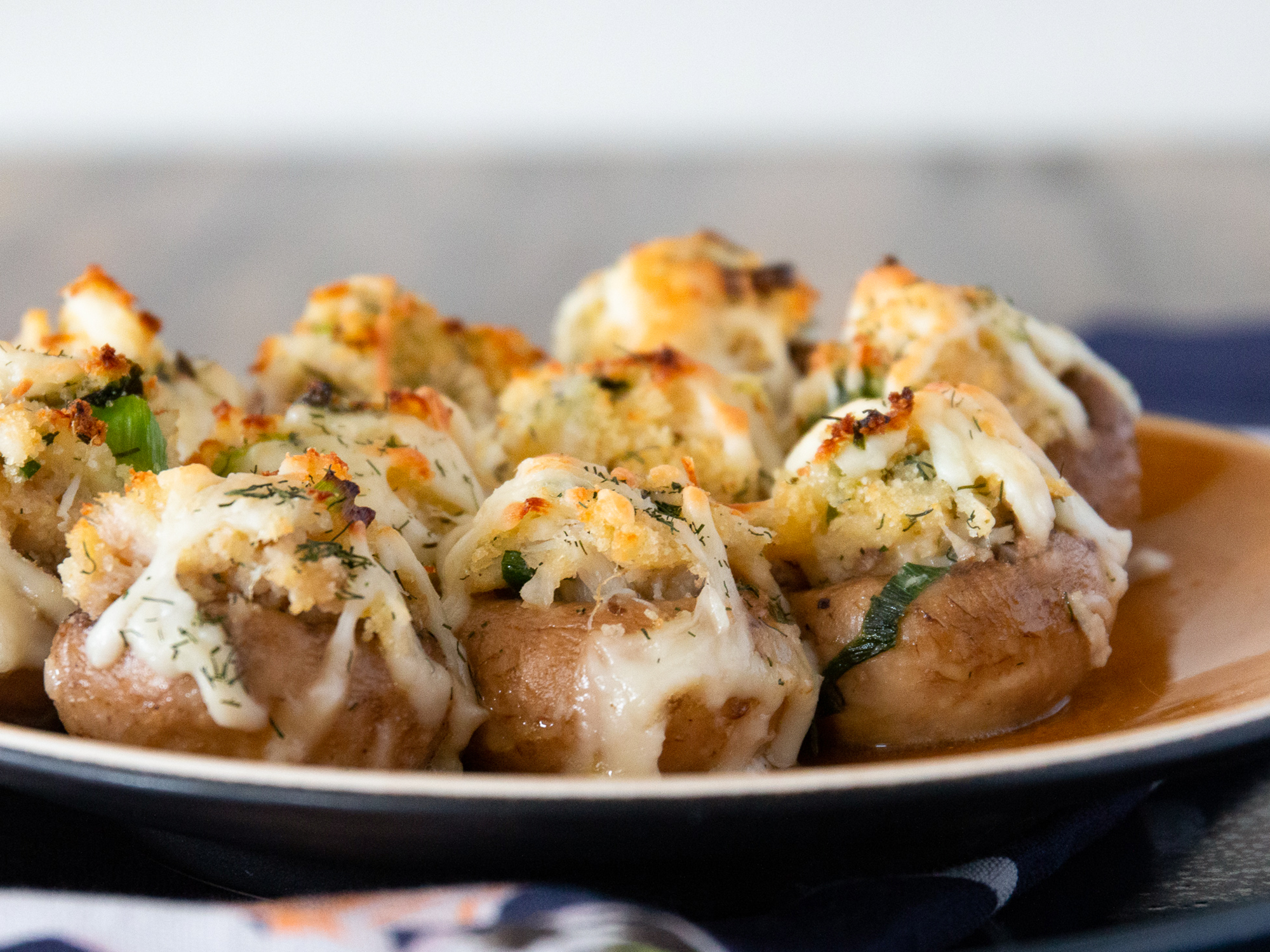 close up view of Crab-Stuffed Mushrooms on a brown platter