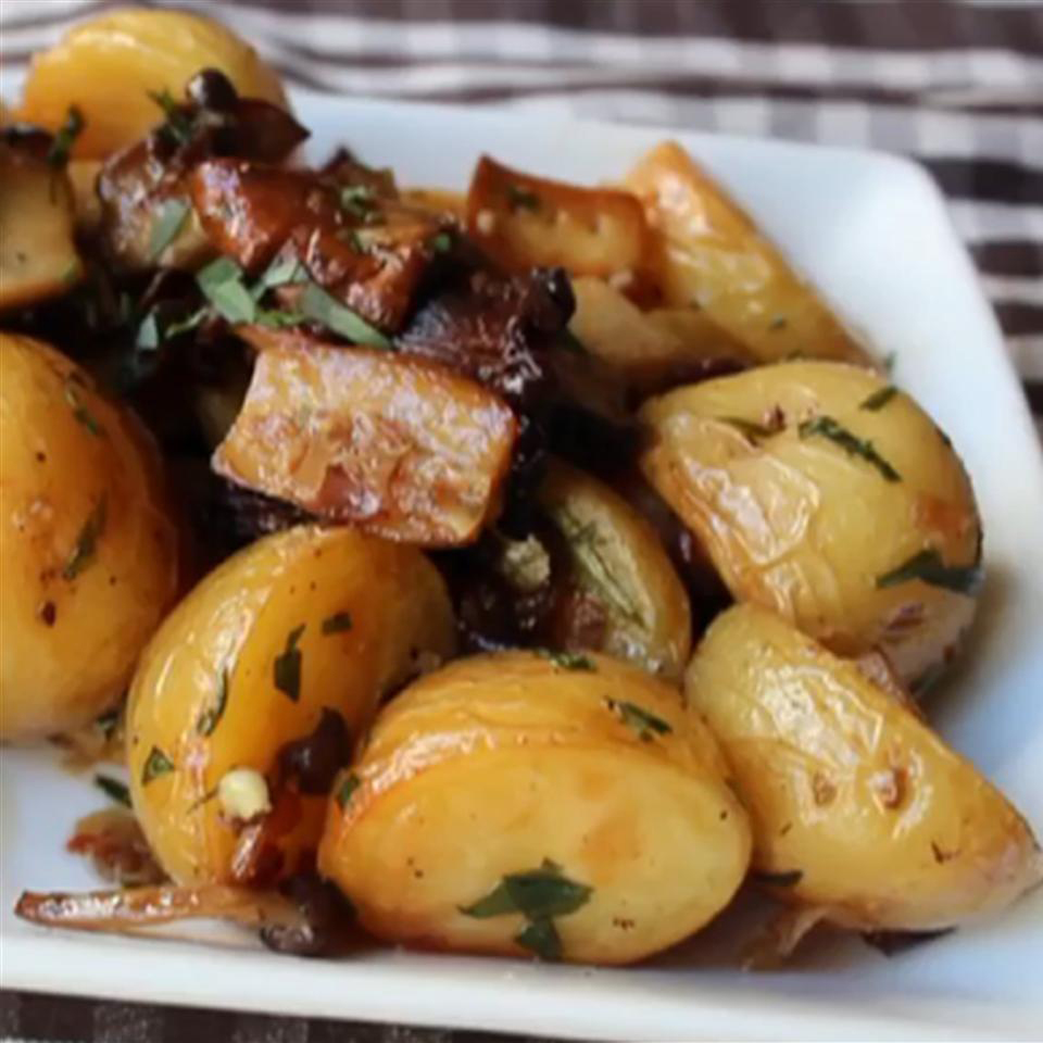 close up view of Roasted Wild Mushrooms and Potatoes with herbs on a white plate