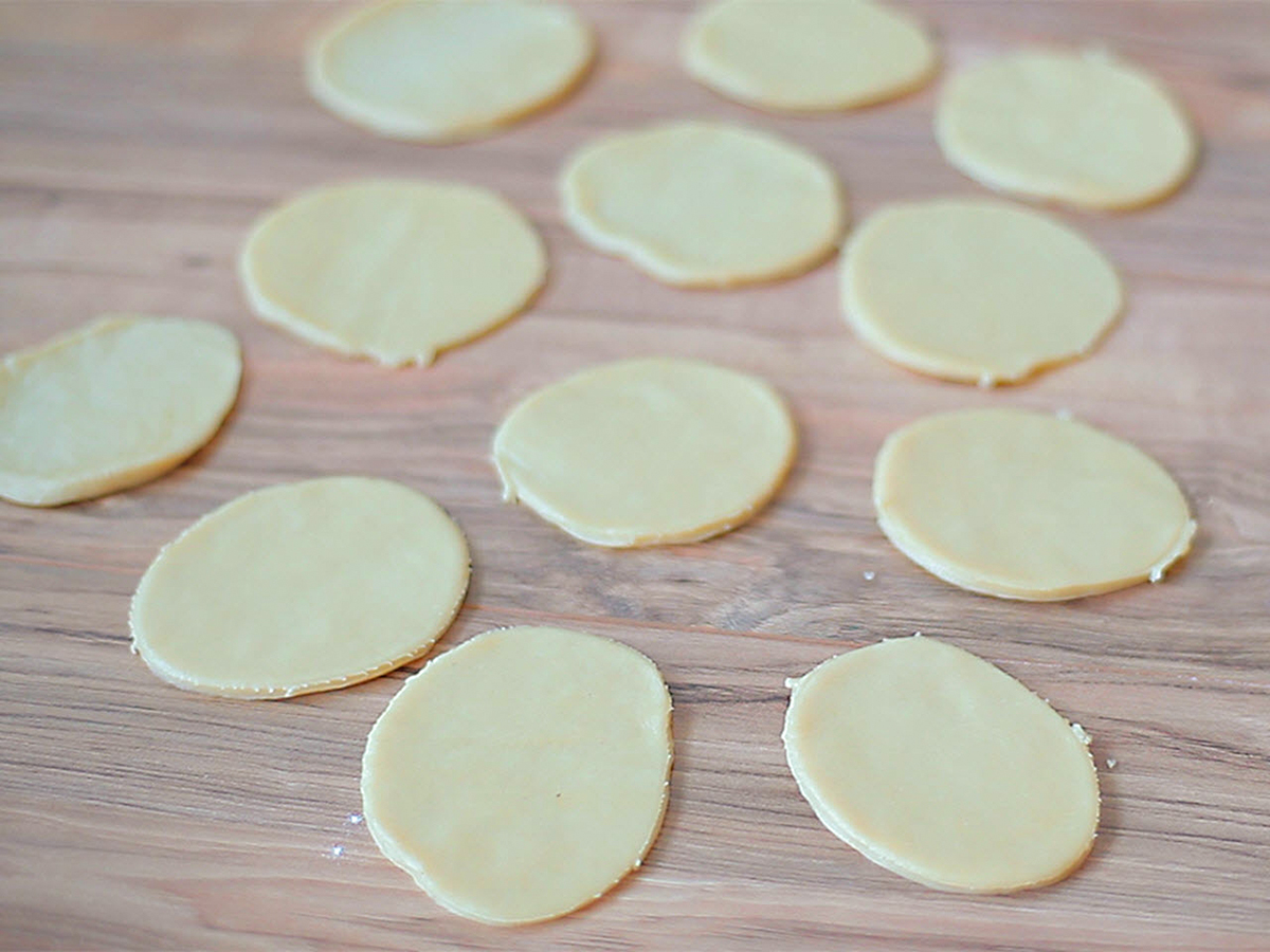 close up view of Empanada Pastry Dough rounds on a wooden surface