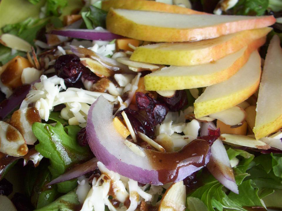 close up view of Cranberry Pear Salad with red onions and cheese in a bowl