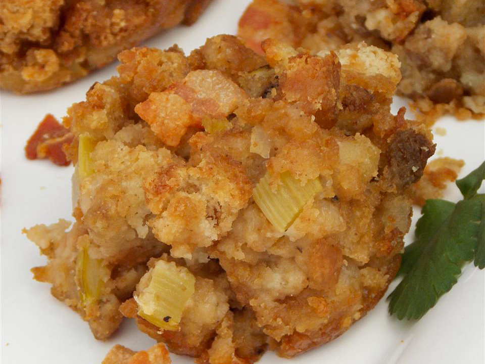 close up view of Bacon Stuffing with fresh herbs on a white plate