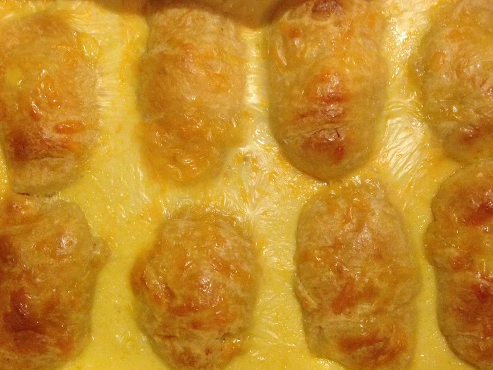 close up view of Cheesy Chicken Rolls in a baking dish