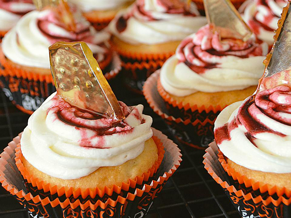 close up view of Bloody Broken Glass Cupcakes with icing in black and orange muffin cups