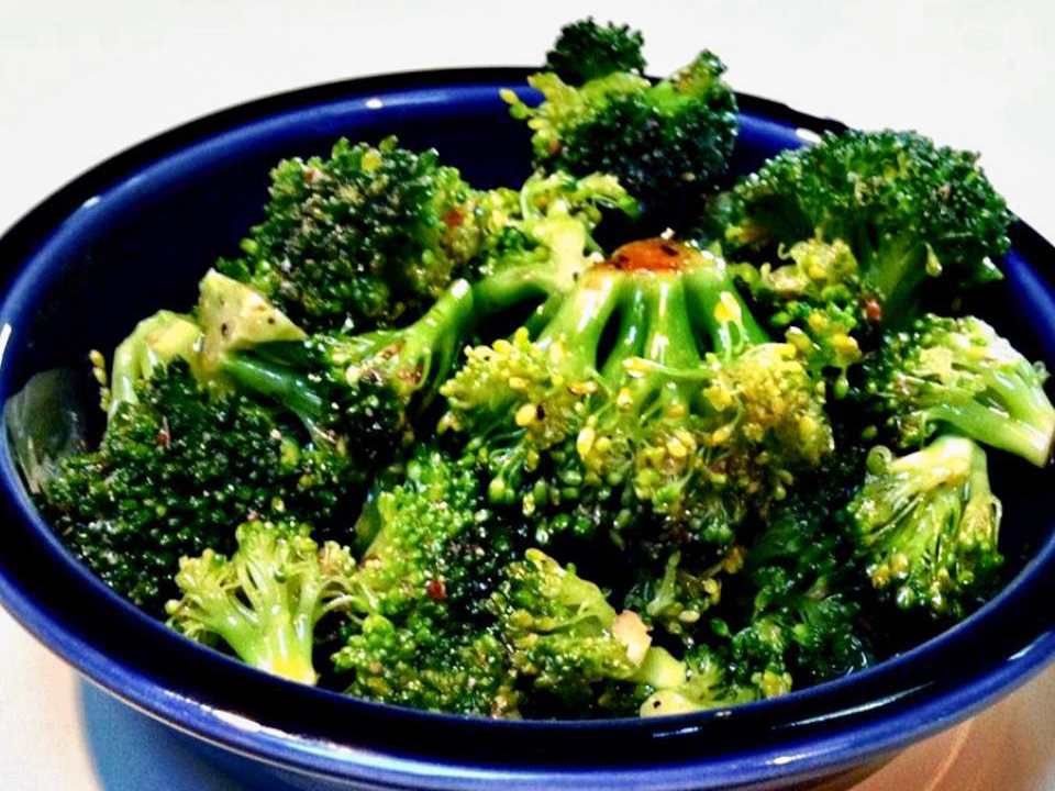close up view of Marinated Broccoli in a blue bowl