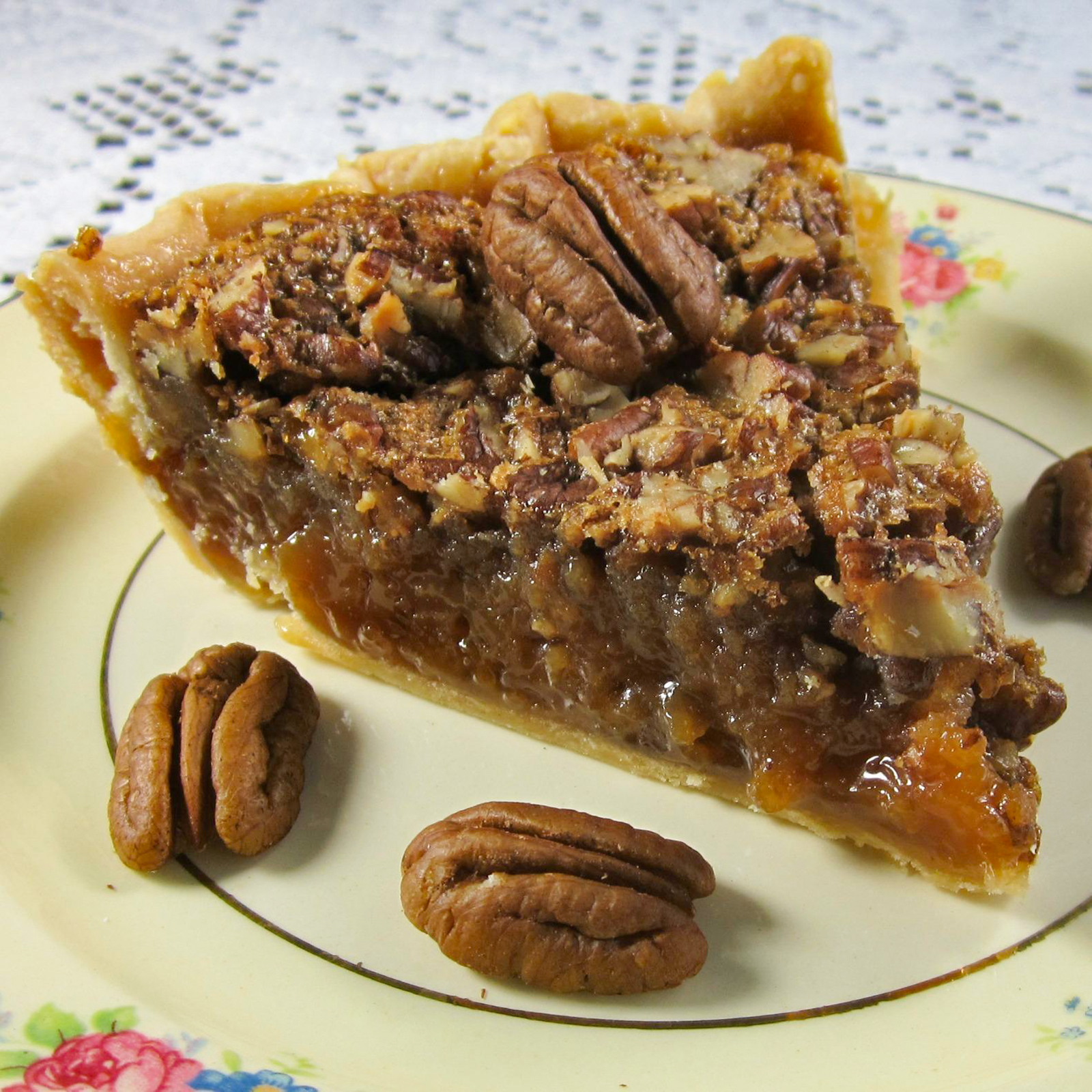 close up view of a slice of Kentucky Pecan Pie on a plate with pecans