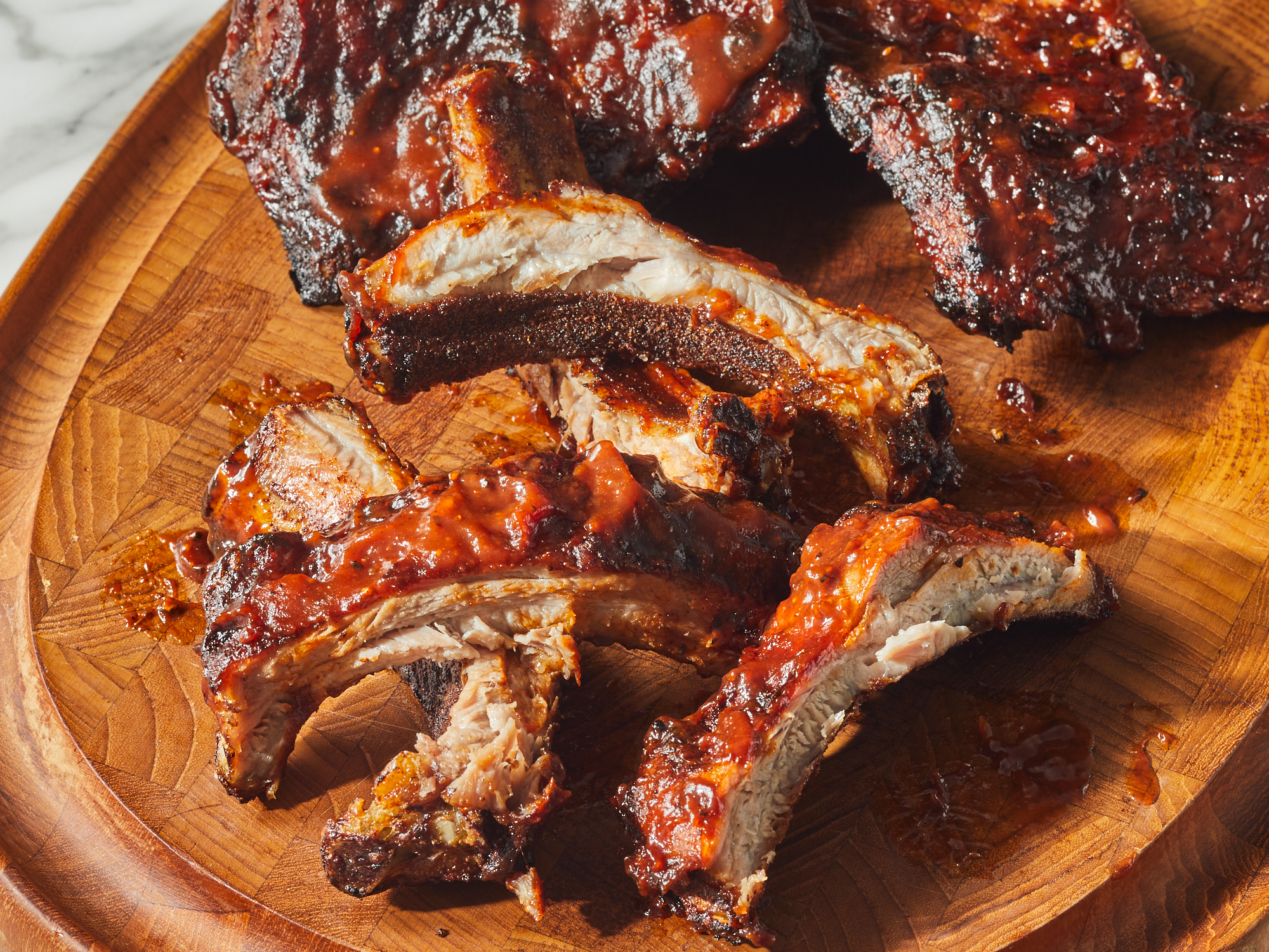 close up on a bunch of air fryer bbq baby back ribs sliced
