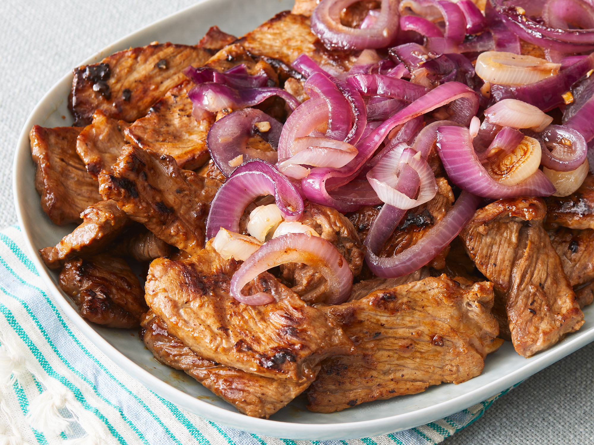 close up on Filipino beef steak topped with some lightly caramelized red onions