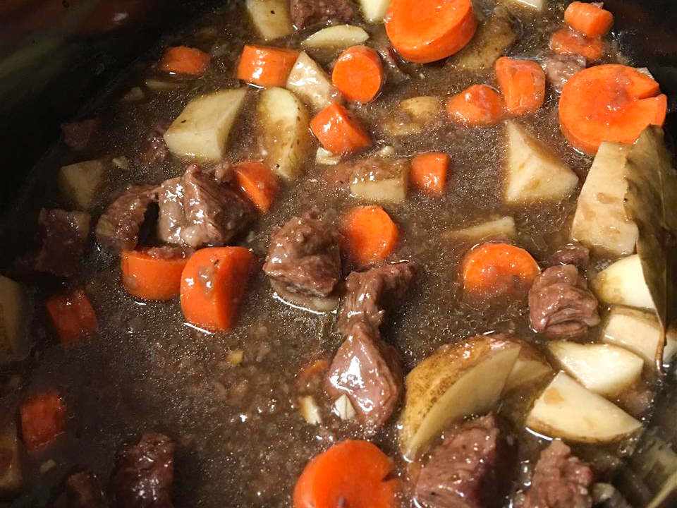 close up view of Guinness Beef Stew with carrots, potatoes and meat in a pot