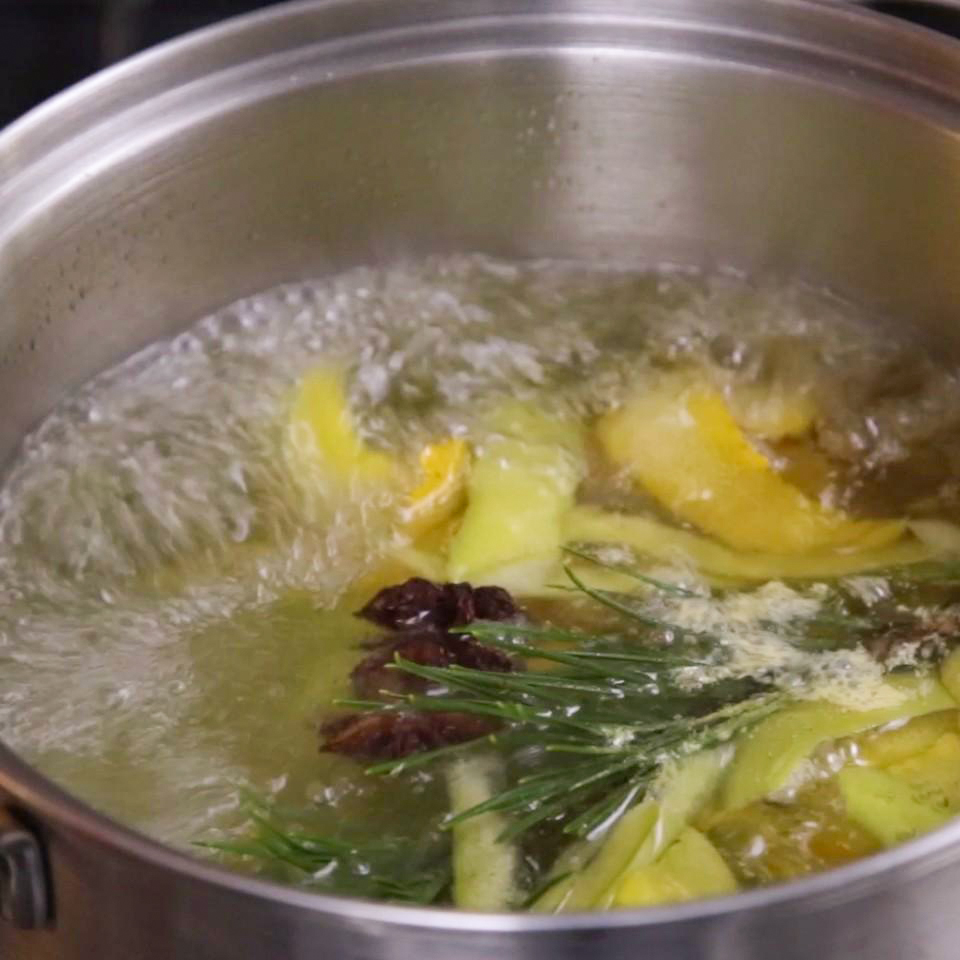close up view of a Winter Simmer Pot with lemon peels, tar anise pods and fresh pine sprigs