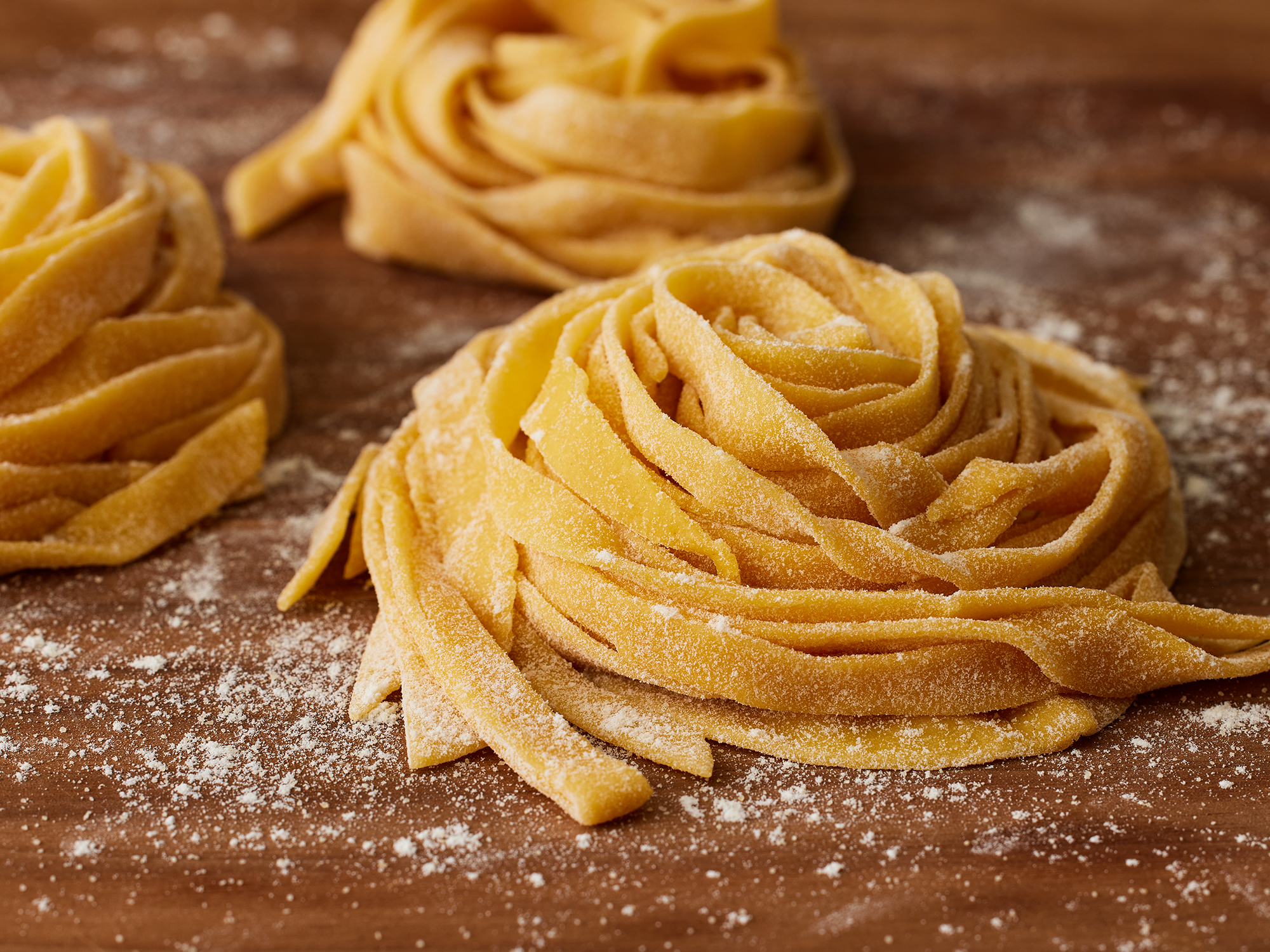 close up on a few piles of fresh semolina and egg pasta