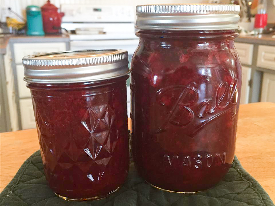 close up view of Lingonberry Jam in glass jars with metals lids