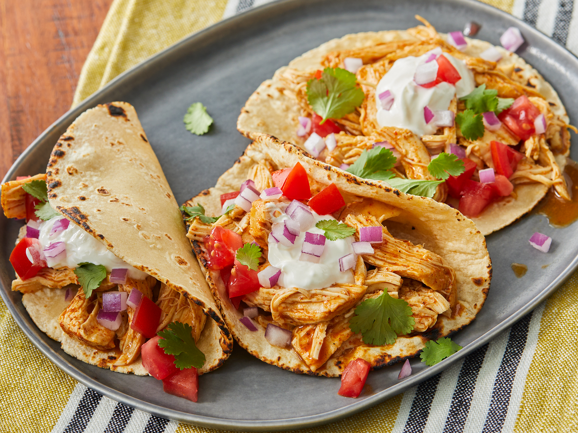 high angle, close up on a plate of three fiesta slow cooker shredded chicken tacos