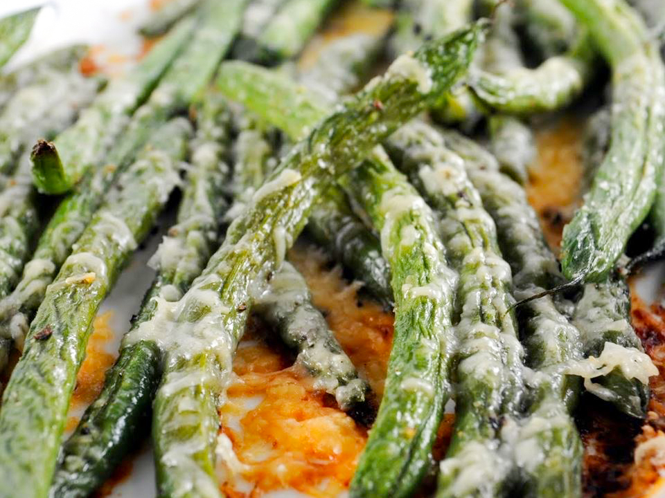 close up view of Parmesan-Roasted Green Beans on a white plate