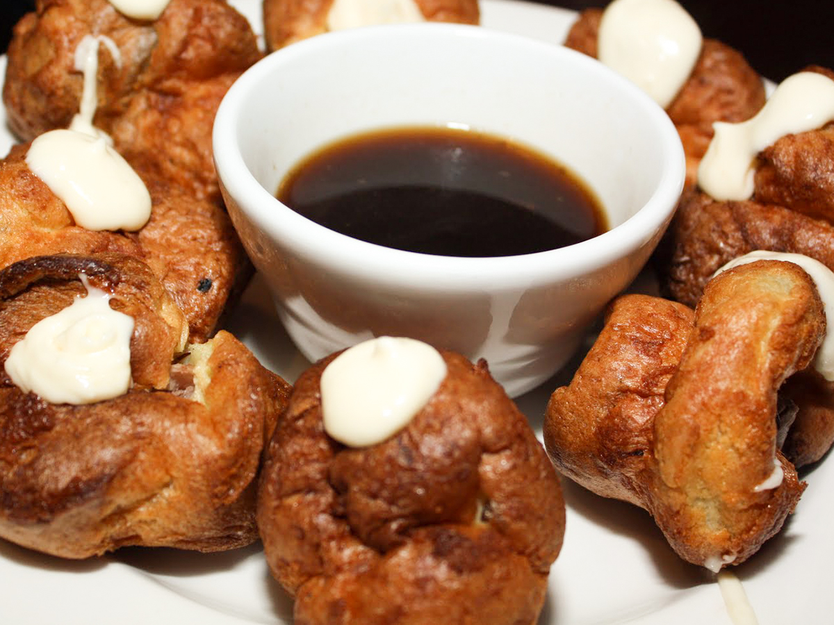 close up view of Stuffed Baby Yorkies pastries, served with au jus in a white bowl