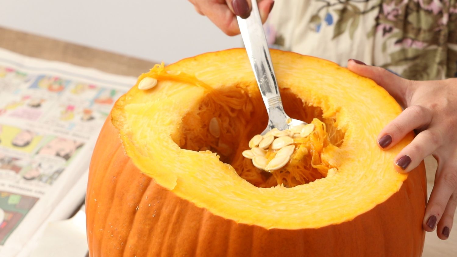 scooping seeds out of pumpkin