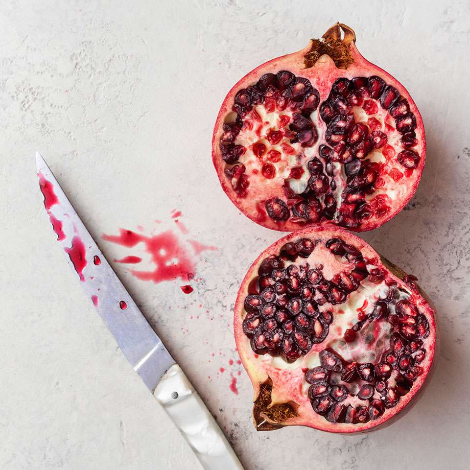 pomegranate cut in half with knife