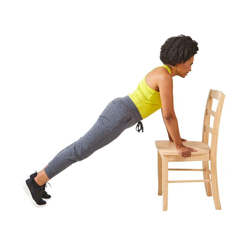 woman doing plant with hands on chair