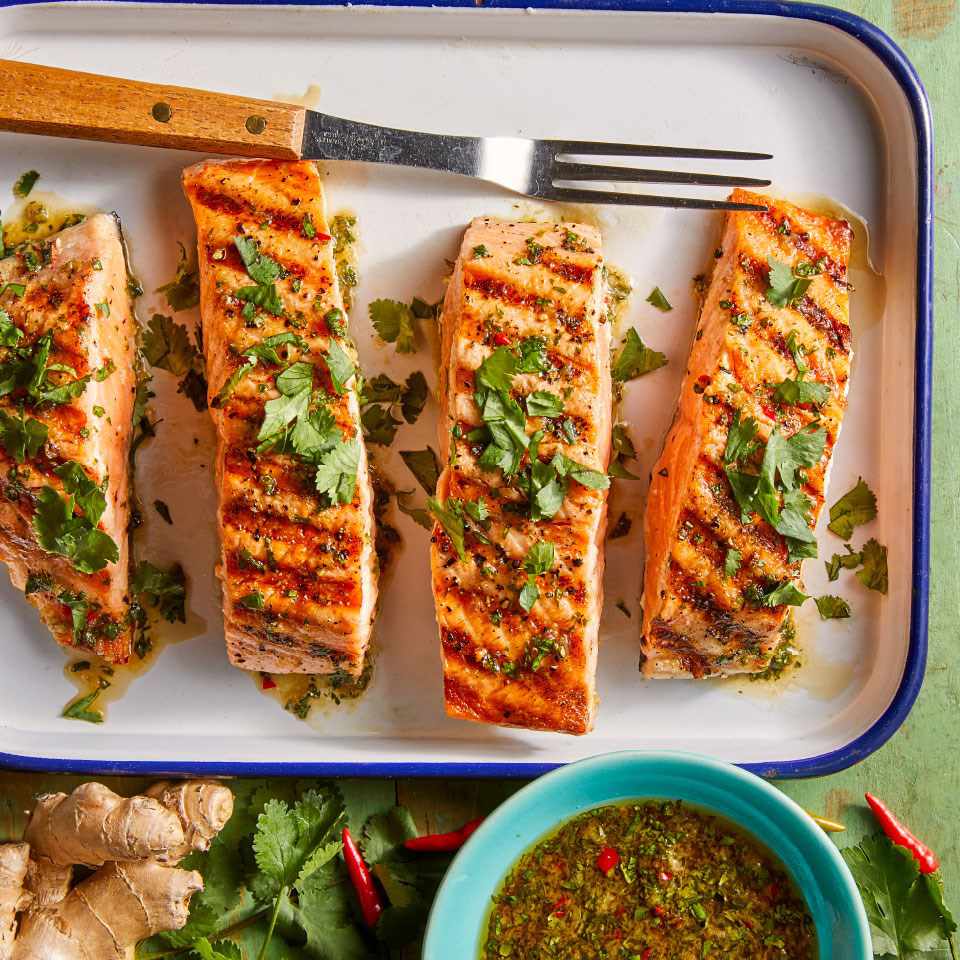 grilled salmon on a platter with fresh cilantro garnish