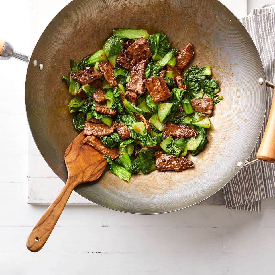 Chinese Ginger Beef Stir-Fry with Baby Bok Choy being cooked in a wok