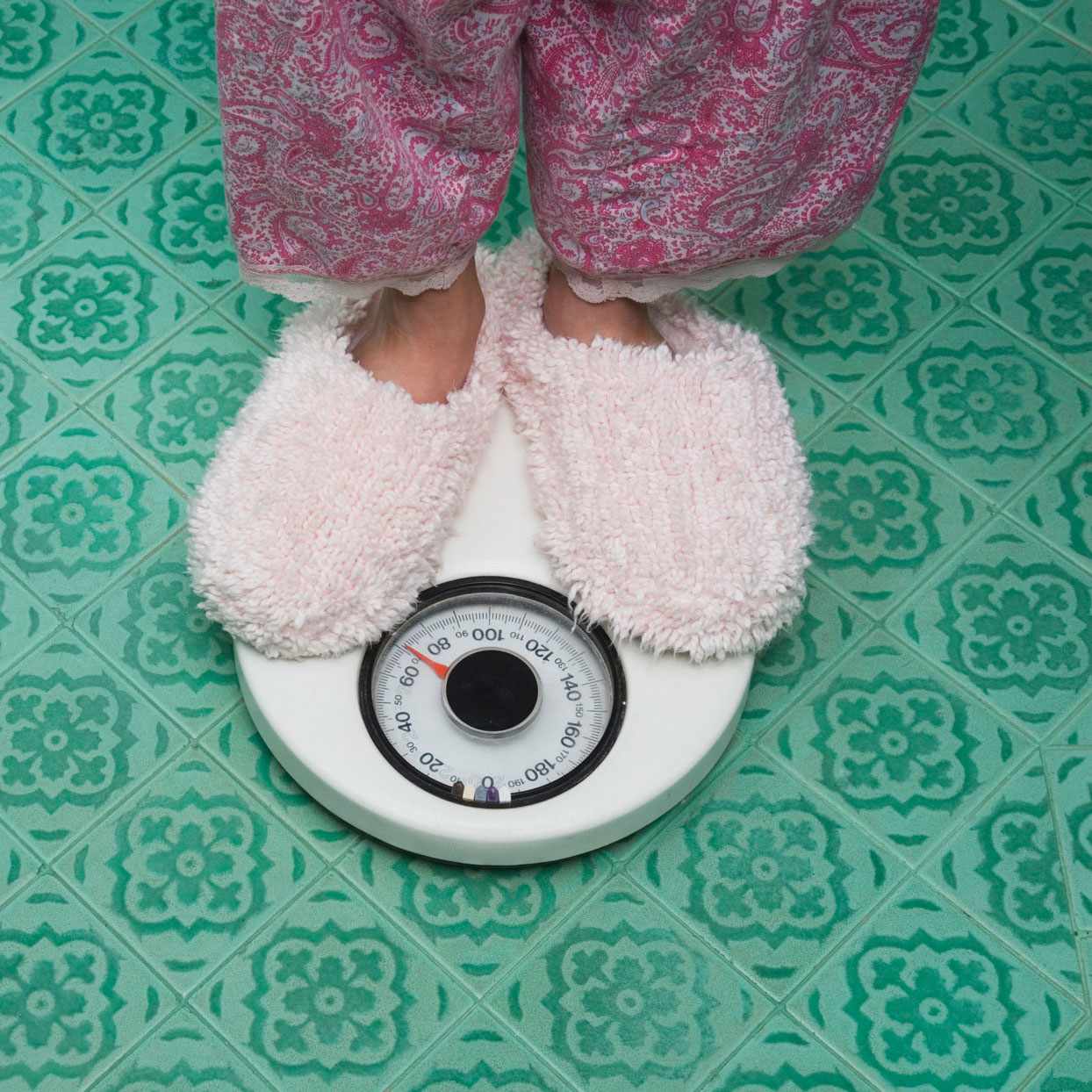 feet with slippers on, standing on a scale